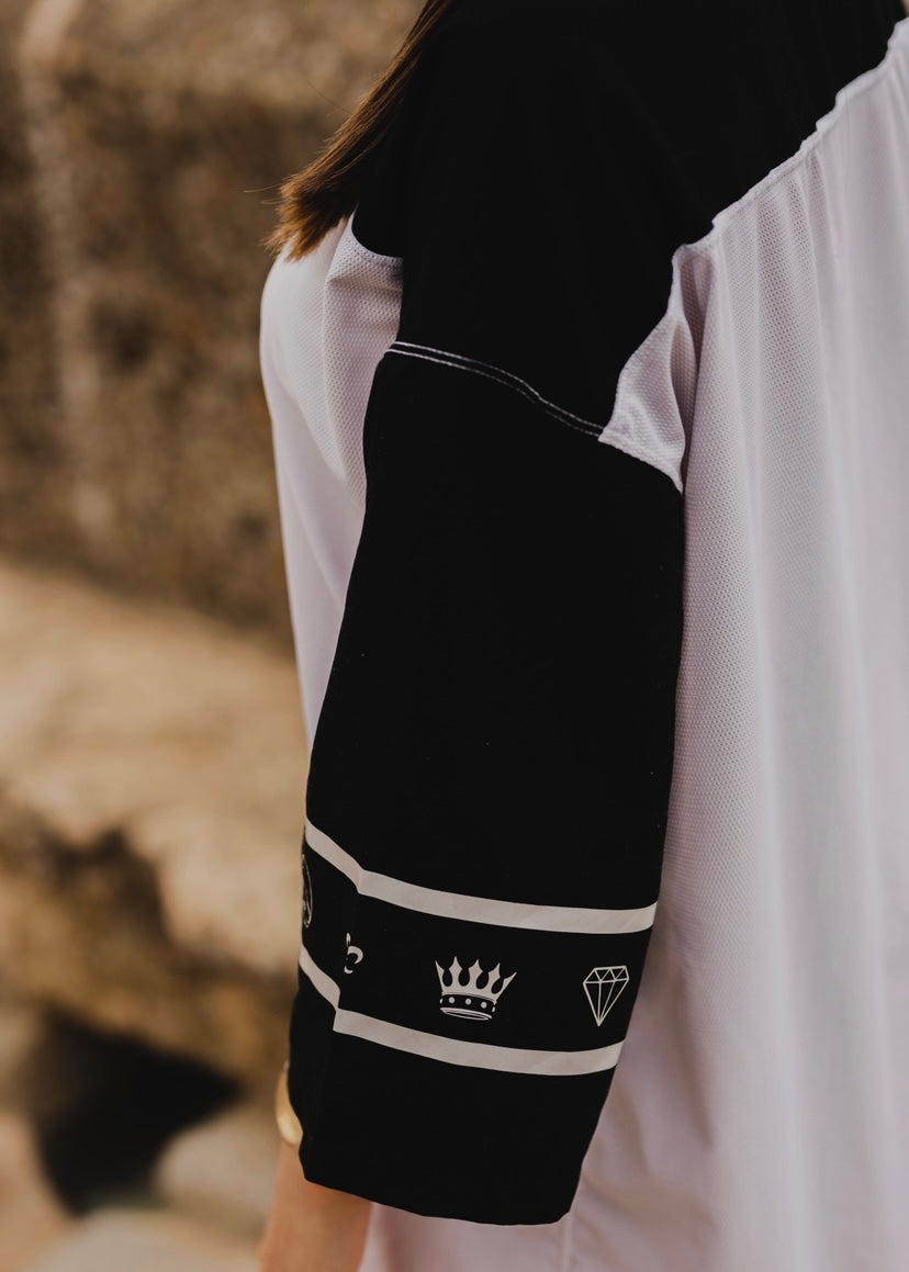 Camiseta blanca y negra con estampado en las mangas.