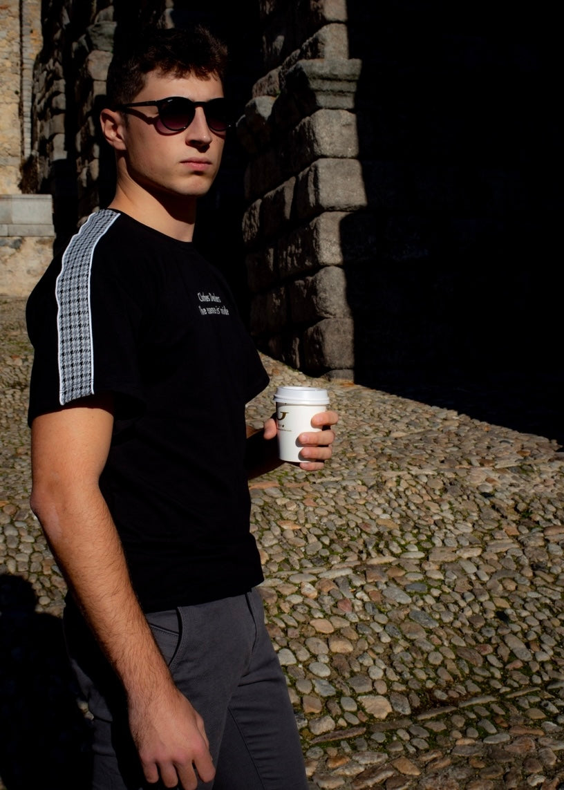 Camiseta negra con bordado frontal y estampado trasero.